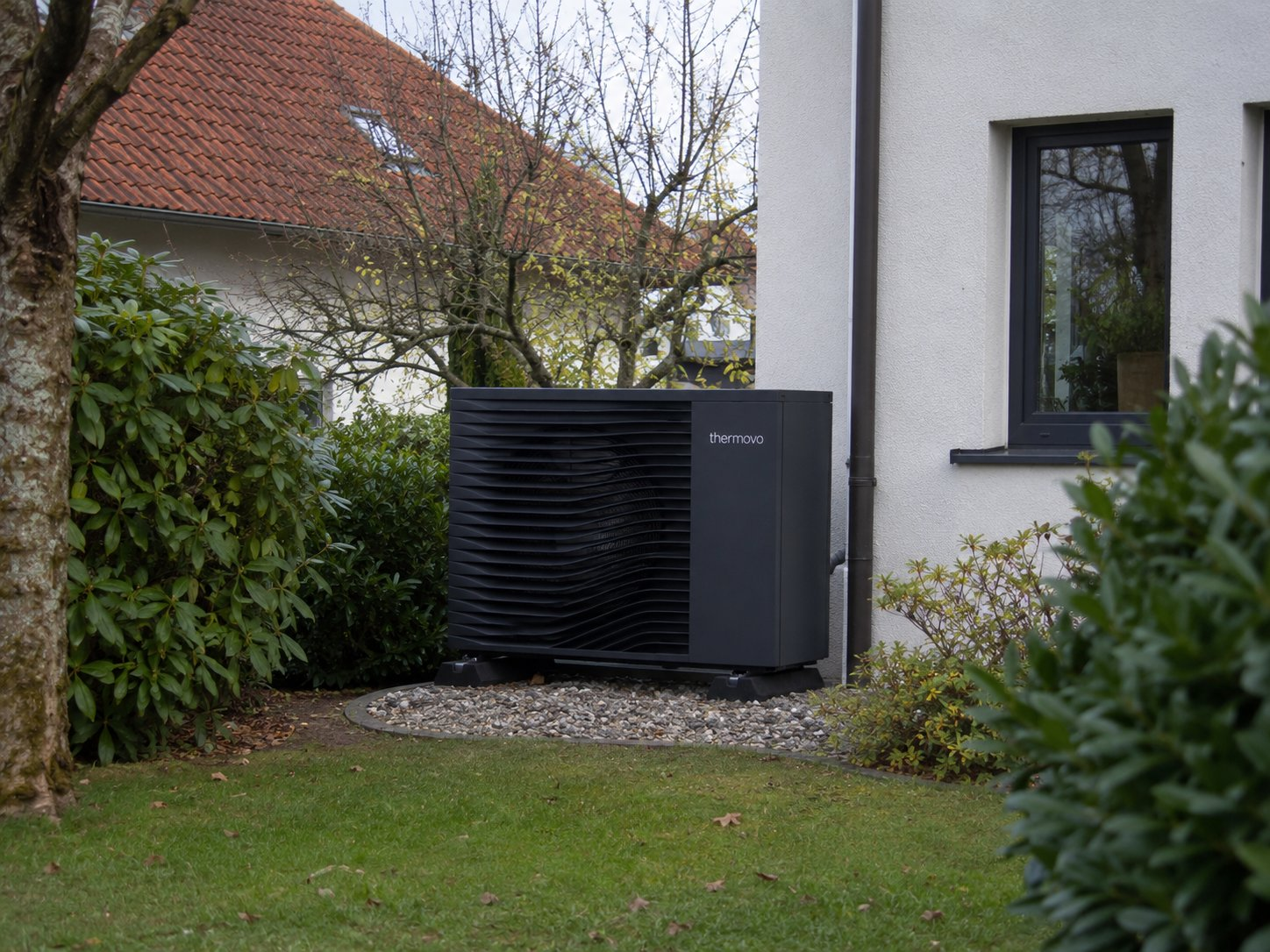 Thermovo air source heat pump outdoor unit installation in progress — mounting bracket, pipe connections, and outdoor placement